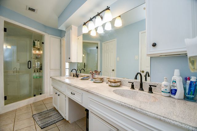 a bathroom with a double vanity sink mirror and shower