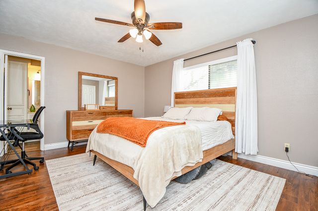 a bedroom with a large bed a chandelier and windows