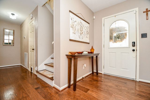 a view of a hallway with wooden floor and windows