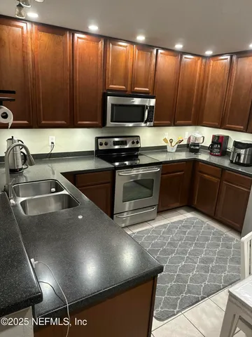 a kitchen with granite countertop a refrigerator stove and microwave