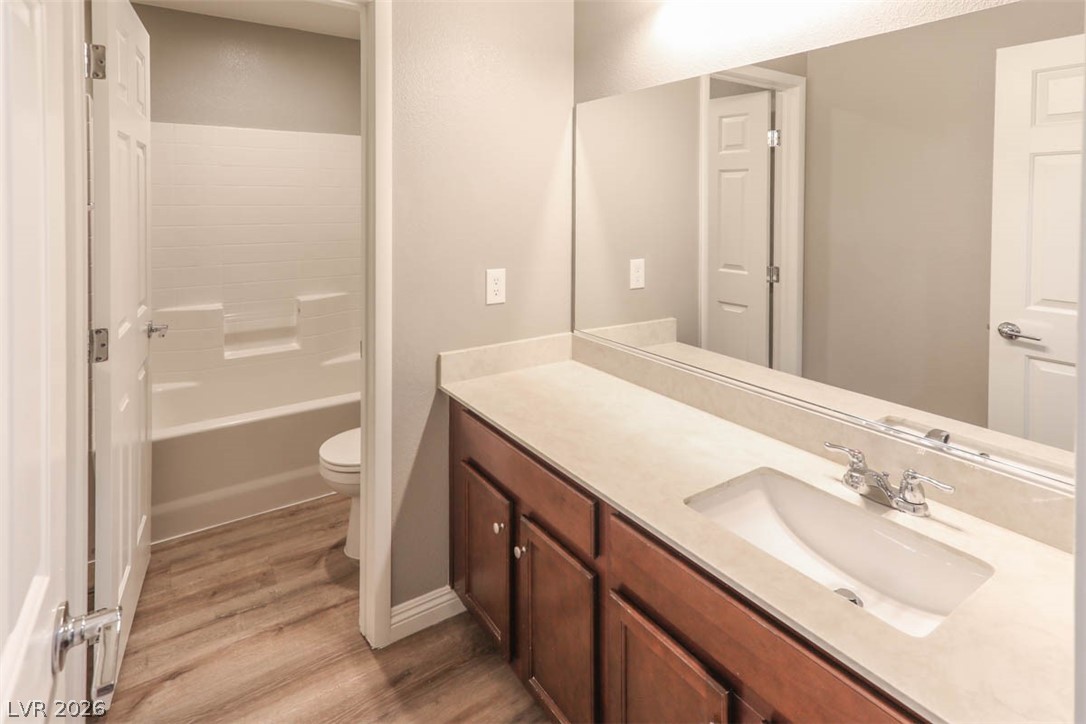 9940 Sable Point Street Las Vegas, NV 89178 - Photo 12 of 40 Full bath featuring wood finished floors, vanity, toilet, and baseboards