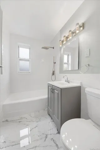 a bathroom with a sink a toilet a mirror and bathtub
