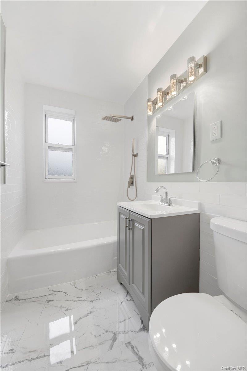 4265 Webster Avenue, Unit 5C Bronx, NY 10470 - Photo 15 of 21 a bathroom with a sink a toilet a mirror and bathtub