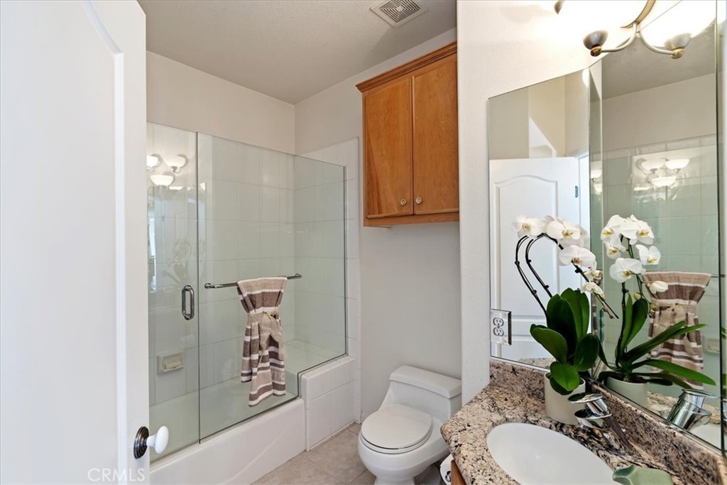 1260 Ransom Road Riverside, CA 92506 - Photo 27 of 50 a bathroom with a granite countertop toilet a sink and shower