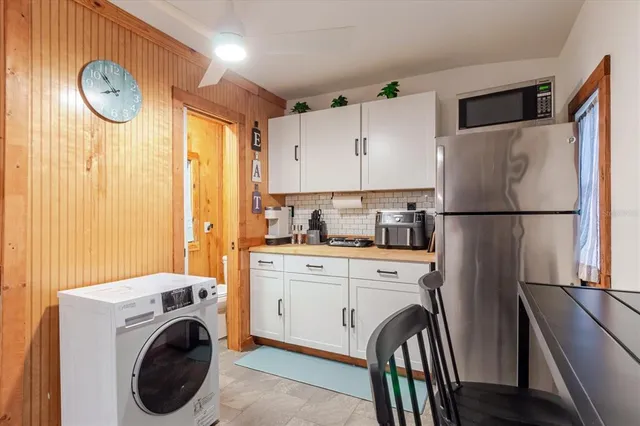 a kitchen that has a sink a stove and chairs