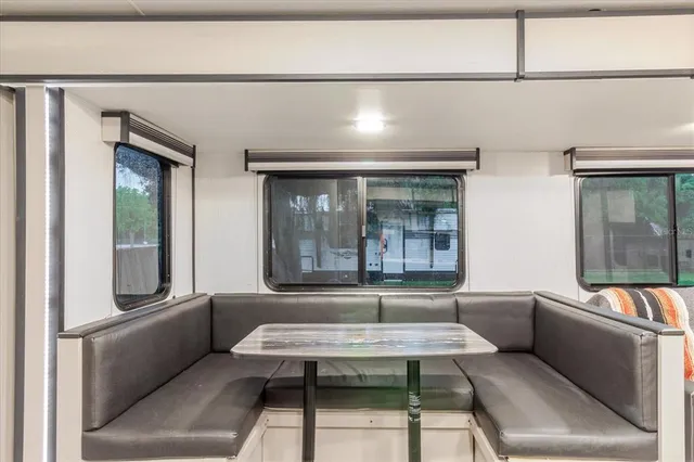 a white house that has a small yard and large trees