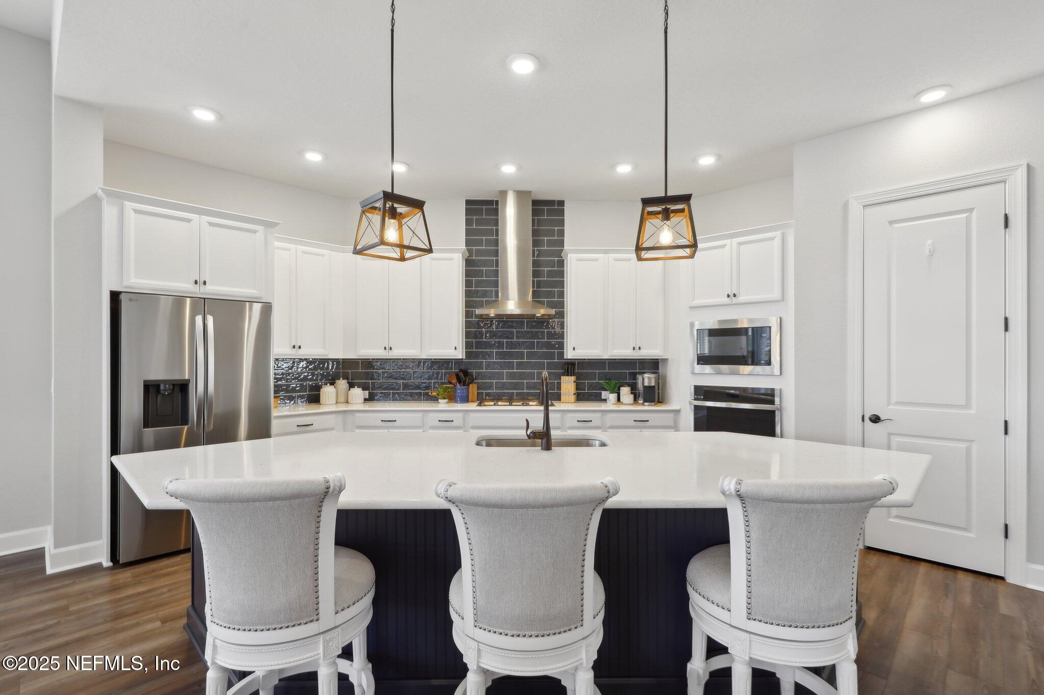 406 Navigators Road St. Johns, FL 32259 - Photo 23 of 57 a kitchen with a dining table chairs sink and microwave