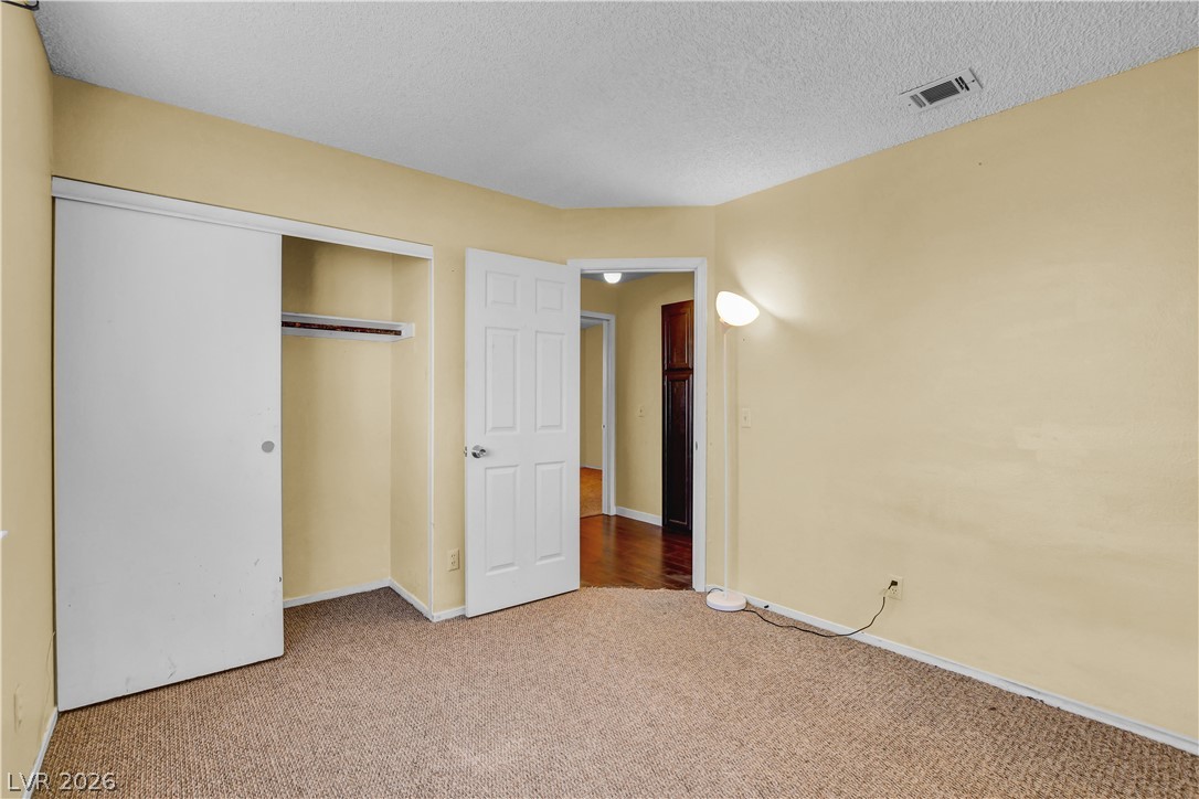 6440 Hartwood Road Las Vegas, NV 89108 - Photo 42 of 59 Step into a comfortable bedroom featuring durable carpet and a convenient sliding closet door.