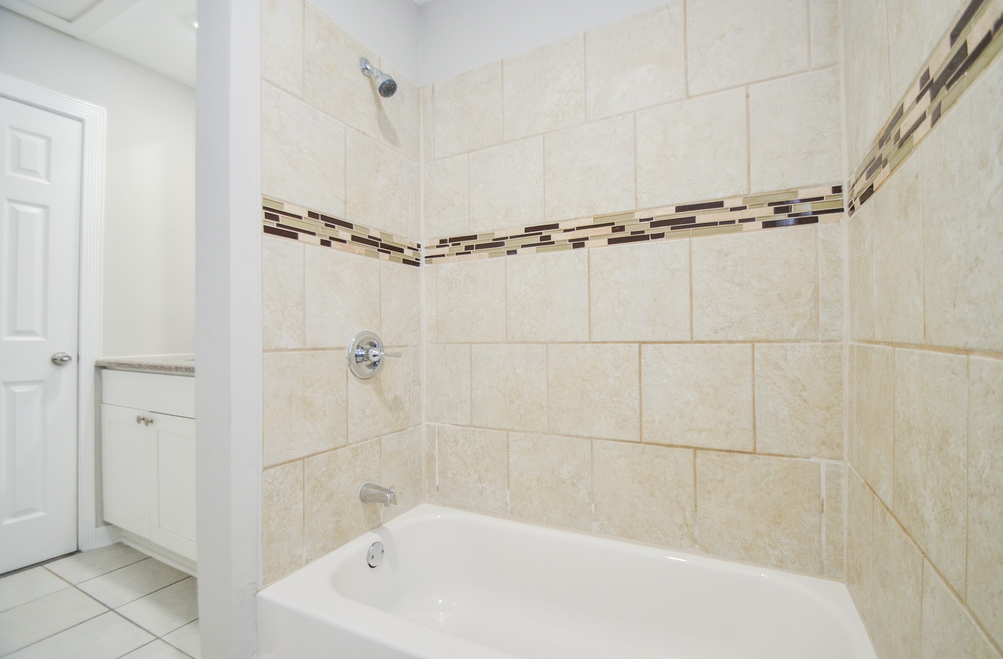 5238 Keystone Street Houston, TX 77021 - Photo 24 of 31 Tub surround with earth tones and accent tile, adding a warm, stylish touch.