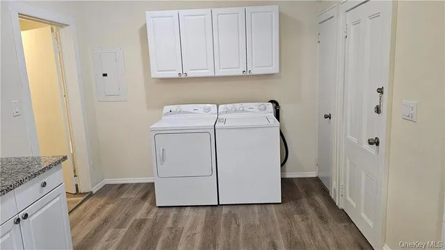a utility room with wooden floor washer and dryer