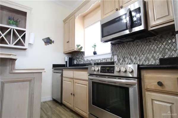 a kitchen with stainless steel appliances granite countertop white cabinets a stove top oven a sink and dishwasher
