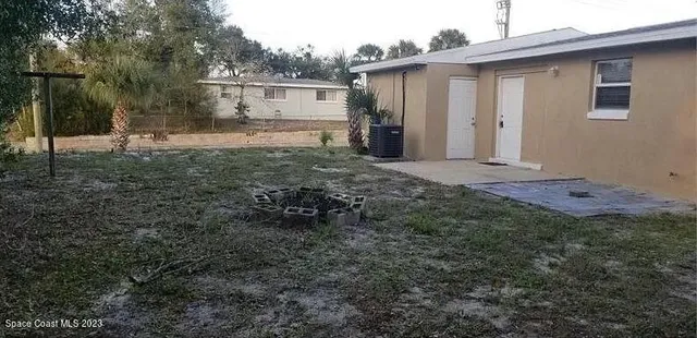 a view of a backyard with large trees and barn