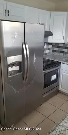 a kitchen with stainless steel appliances granite countertop a refrigerator a stove and a sink