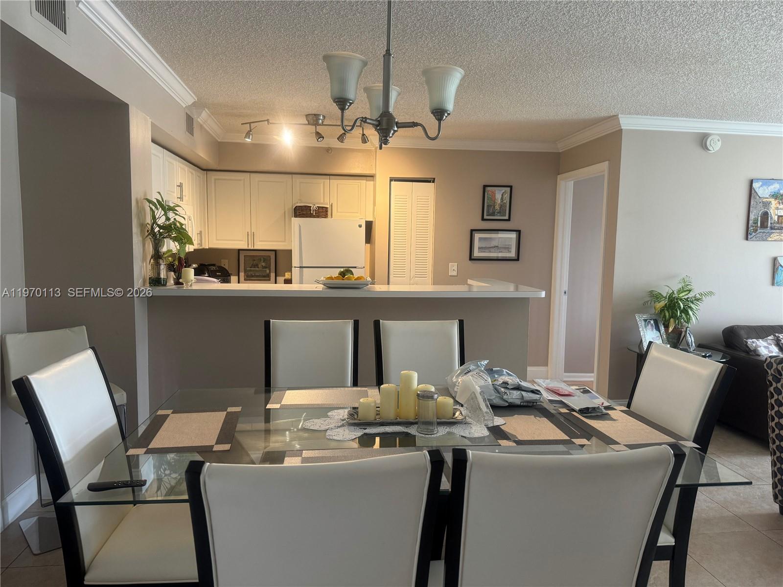 2091 Renaissance Boulevard, Unit 104 Miramar, FL 33025 - Photo 11 of 31 a room with a table chairs and a chandelier