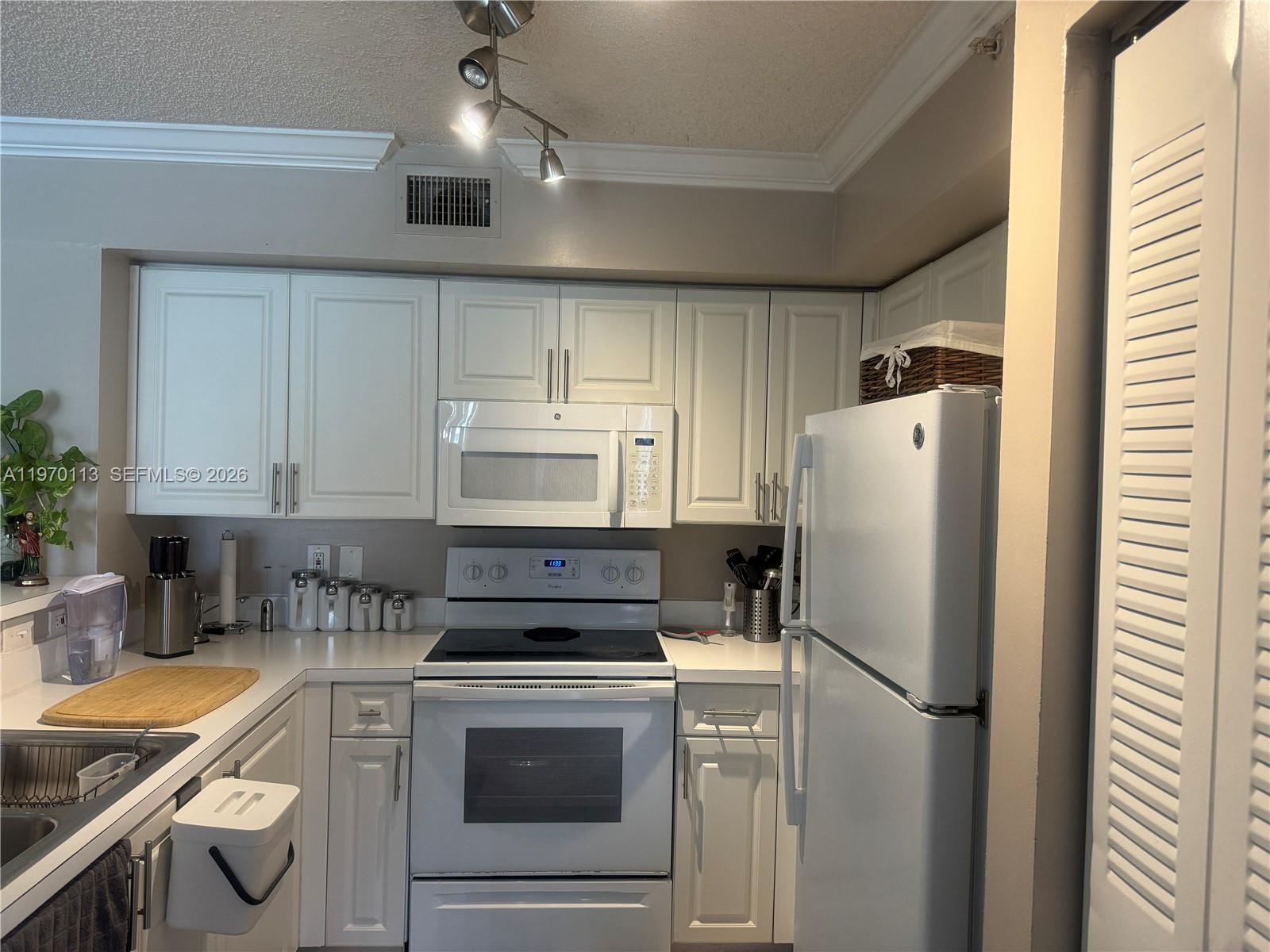 2091 Renaissance Boulevard, Unit 104 Miramar, FL 33025 - Photo 12 of 31 a kitchen with stainless steel appliances granite countertop a refrigerator sink and stove