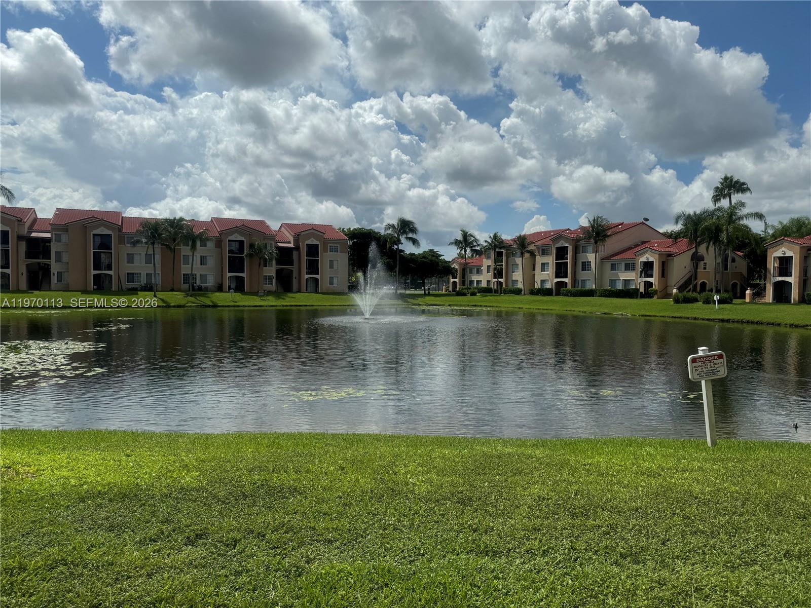 2091 Renaissance Boulevard, Unit 104 Miramar, FL 33025 - Photo 2 of 31 a view of a lake with a house in the background