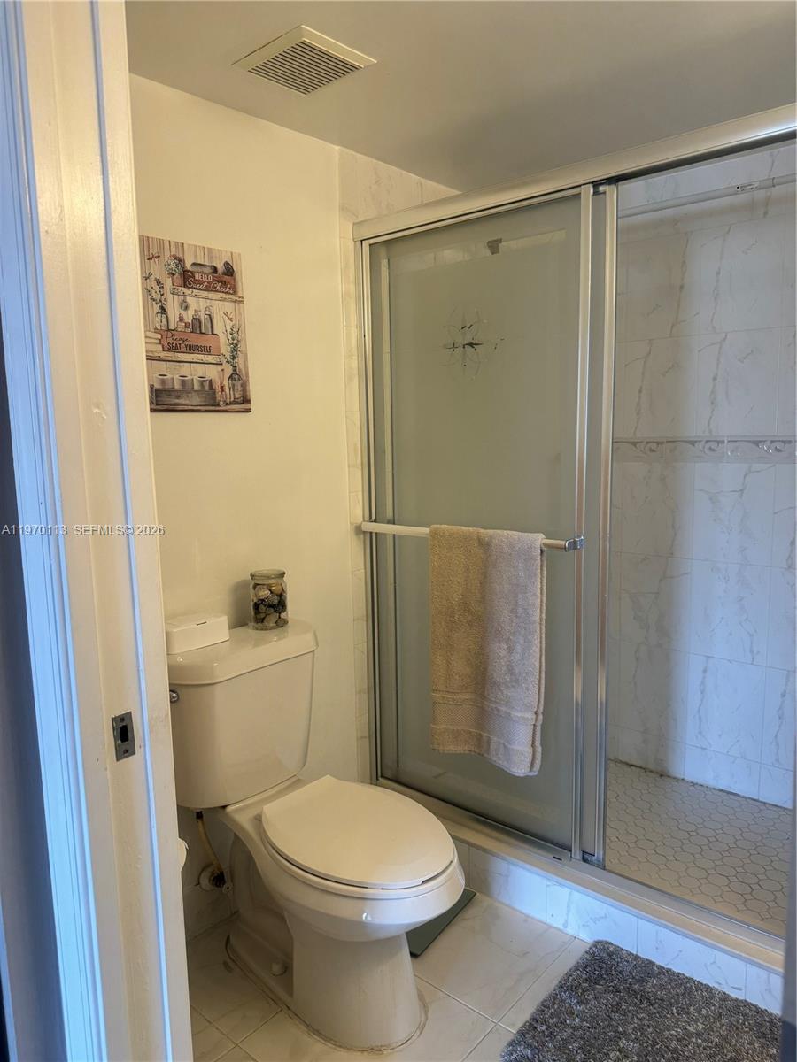 2091 Renaissance Boulevard, Unit 104 Miramar, FL 33025 - Photo 25 of 31 a bathroom with a toilet and a shower