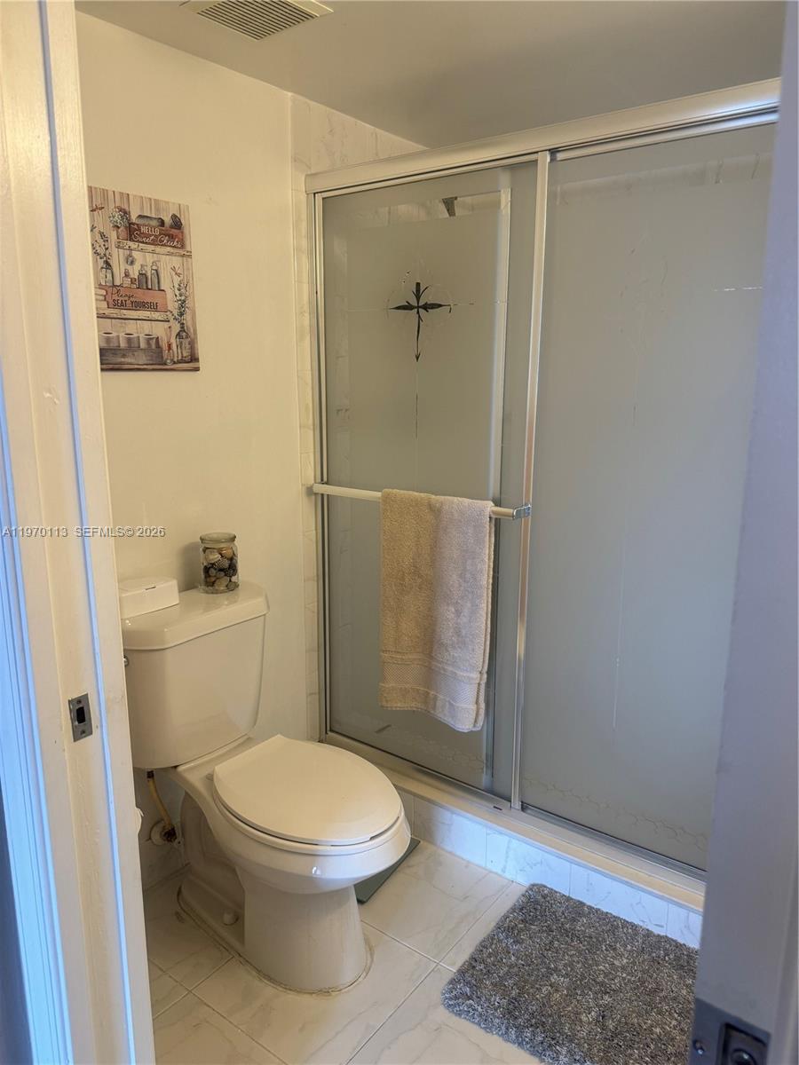 2091 Renaissance Boulevard, Unit 104 Miramar, FL 33025 - Photo 27 of 31 a white toilet sitting next to a bathroom sink