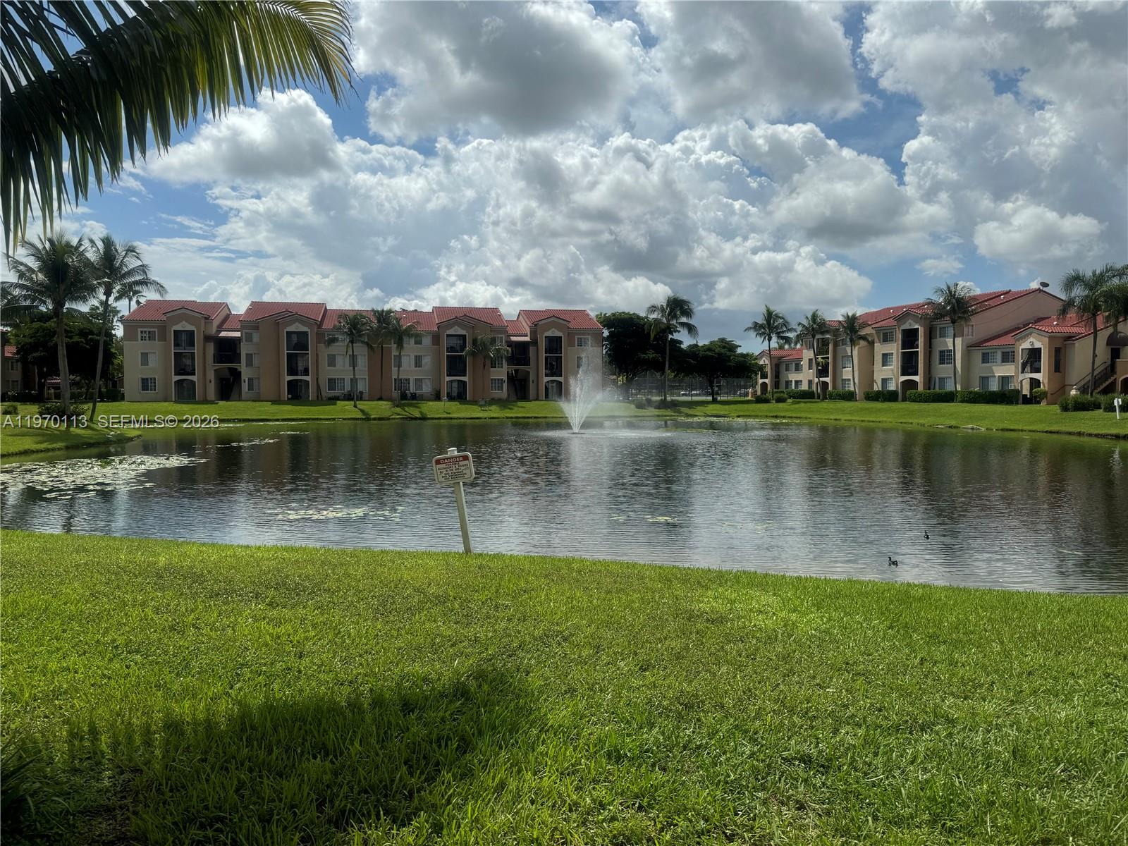 2091 Renaissance Boulevard, Unit 104 Miramar, FL 33025 - Photo 3 of 31 a view of a lake with a house in the background