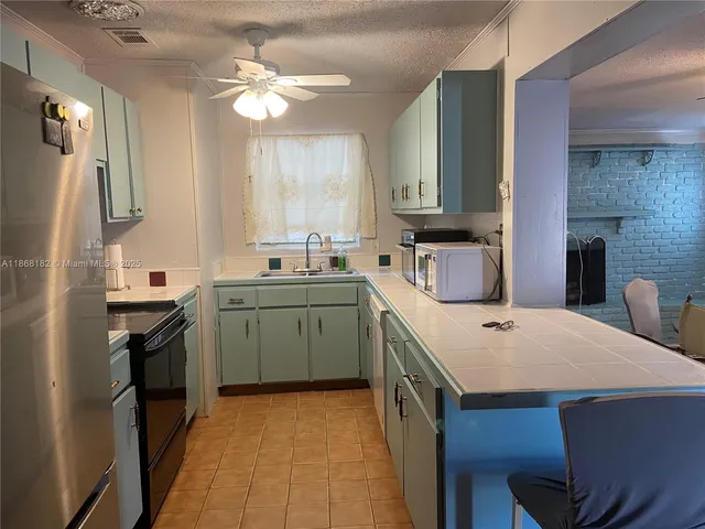 a kitchen that has a sink a stove and a refrigerator