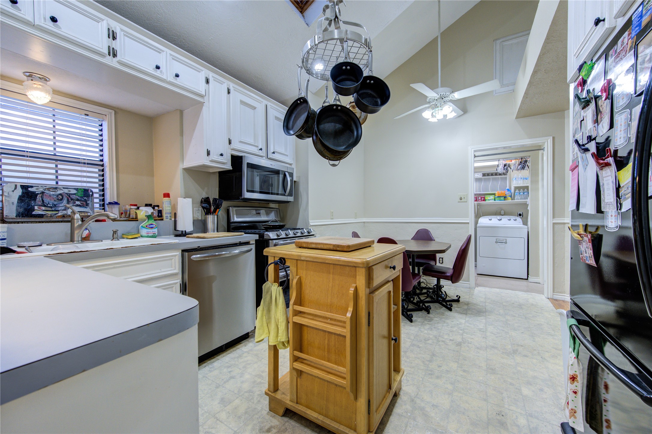 11217 Todd Street Houston, TX 77055 - Photo 12 of 49 a kitchen with stainless steel appliances granite countertop a sink dishwasher a microwave oven a stove with a dining table and chairs with wooden floor