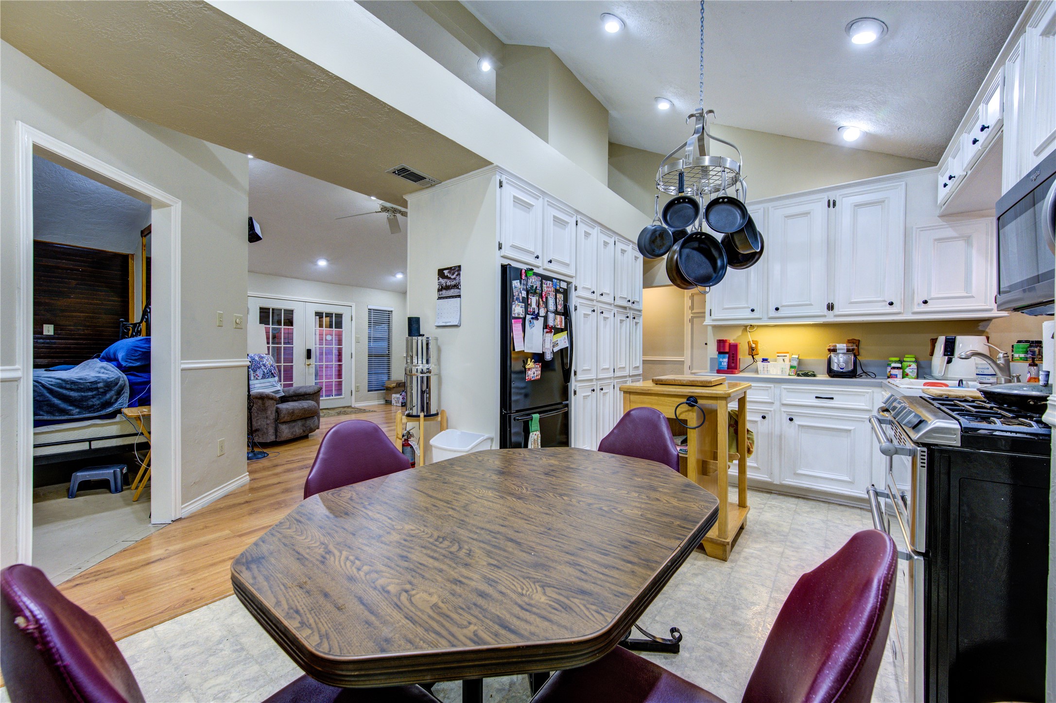 11217 Todd Street Houston, TX 77055 - Photo 14 of 49 a kitchen with stainless steel appliances granite countertop a stove a refrigerator a dining table and chairs with wooden floor