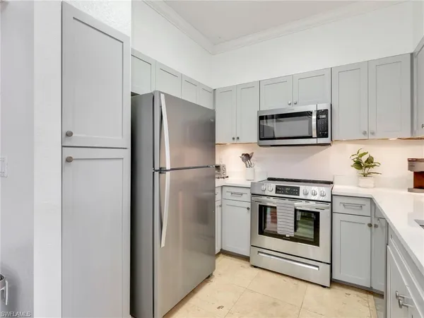 a kitchen with white cabinets and appliances