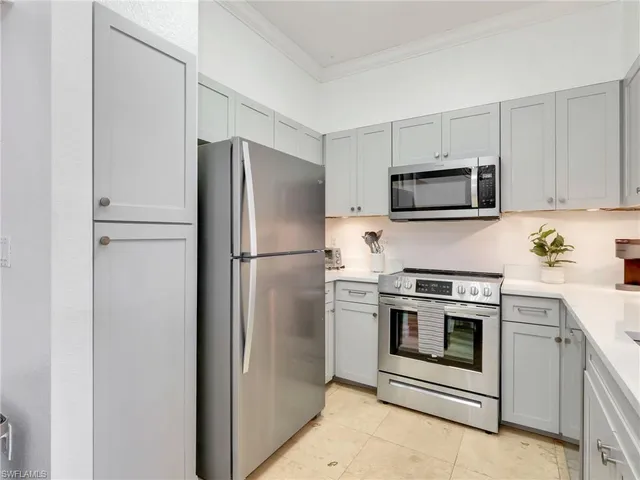 a kitchen with white cabinets and appliances