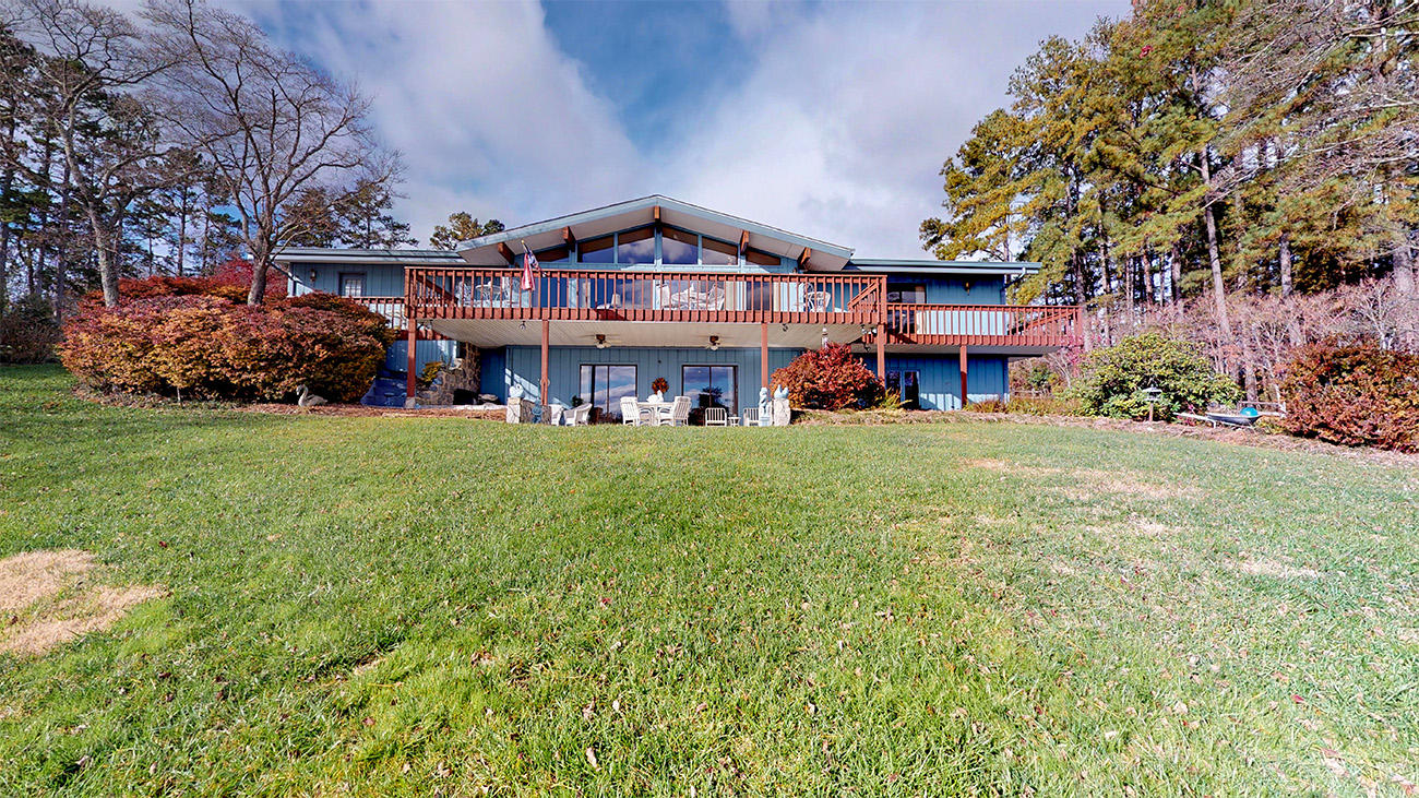 a view of a big house with a big yard and large trees
