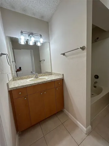 a bathroom with a double vanity sink a mirror and a bathtub