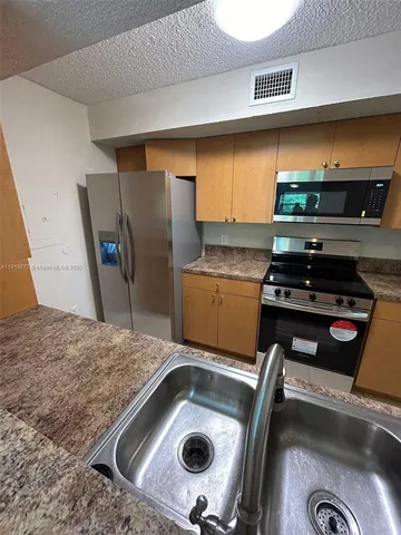 a kitchen with a stove a refrigerator and a sink