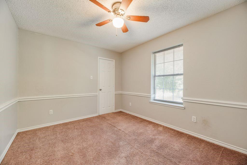 5610 Eagle Rock Road Arlington, TX 76017 - Photo 15 of 33 Spacious room featuring neutral paint, brown carpeting, a ceiling fan with light fixture, white trim, and a window with blinds
