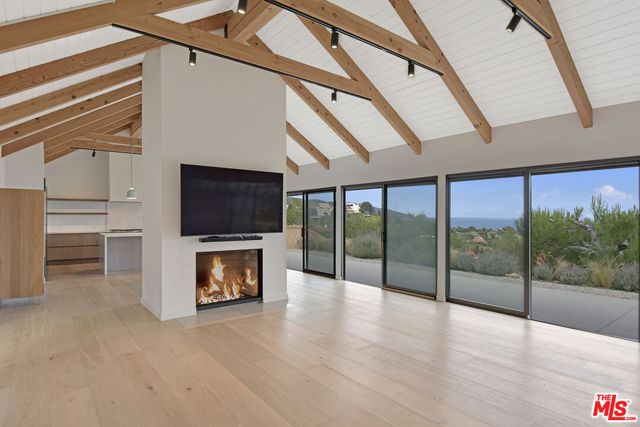 a large kitchen with stainless steel appliances a large counter top a refrigerator and cabinets