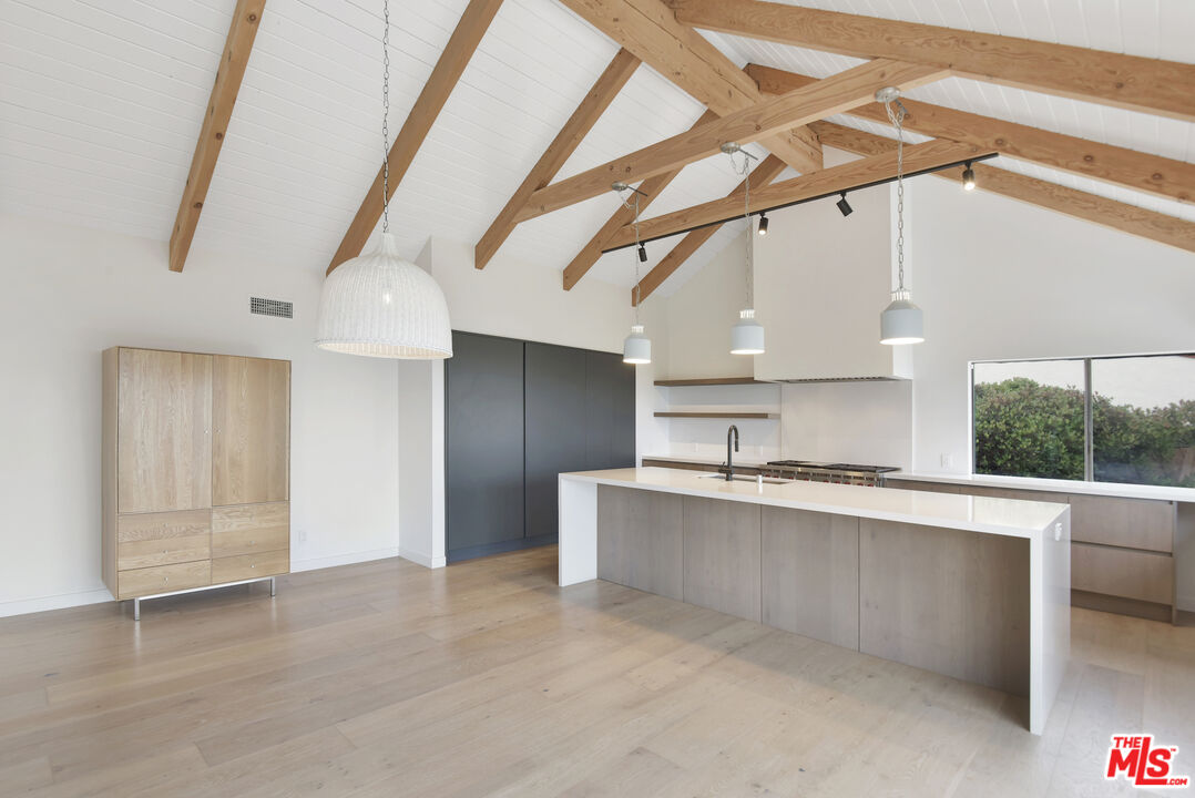 24728 Vantage Point Terrace Malibu, CA 90265 - Photo 8 of 36 a large kitchen with stainless steel appliances a large counter top a refrigerator and cabinets