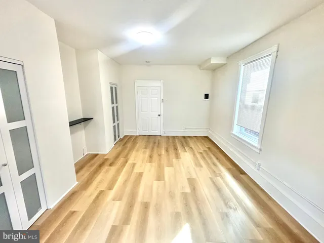 a view of a room with wooden floor and white walls