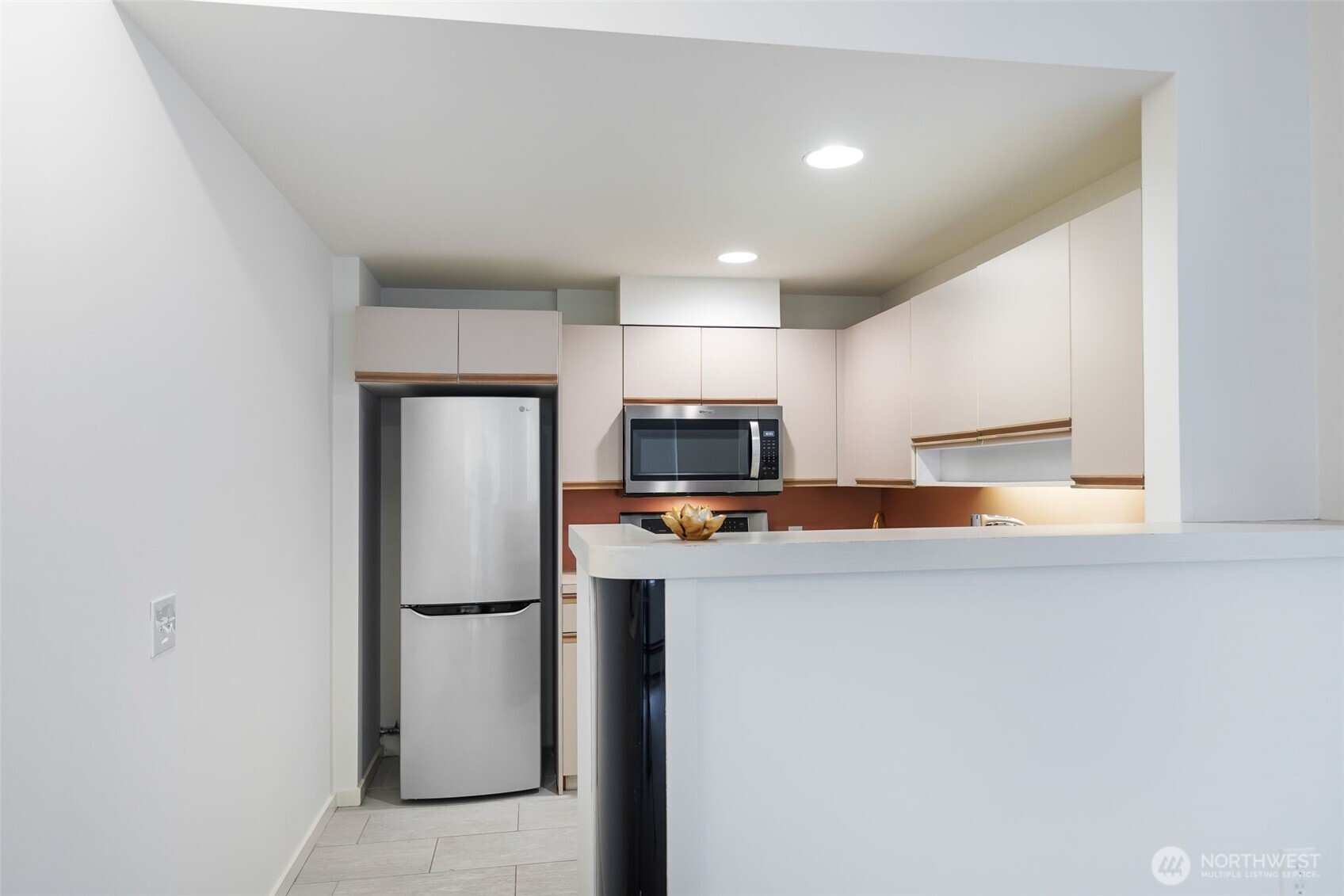 98 Union Street, Unit 408 Seattle, WA 98101 - Photo 9 of 30 a kitchen with stainless steel appliances a refrigerator and a stove top oven