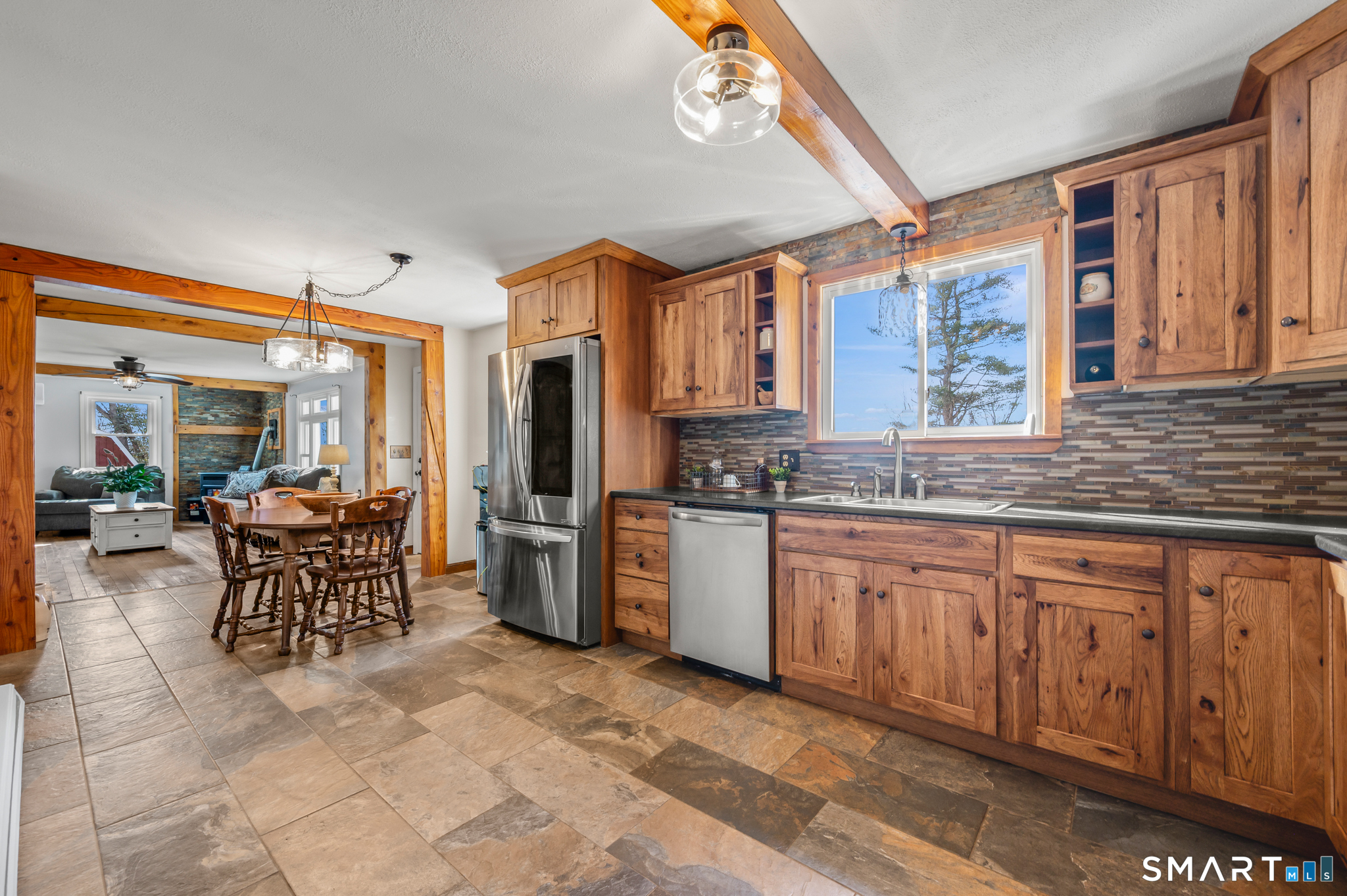 64 Westford Road Eastford, CT 06242 - Photo 14 of 40 a kitchen with stainless steel appliances granite countertop a refrigerator a sink dishwasher a dining table and chairs with wooden floor