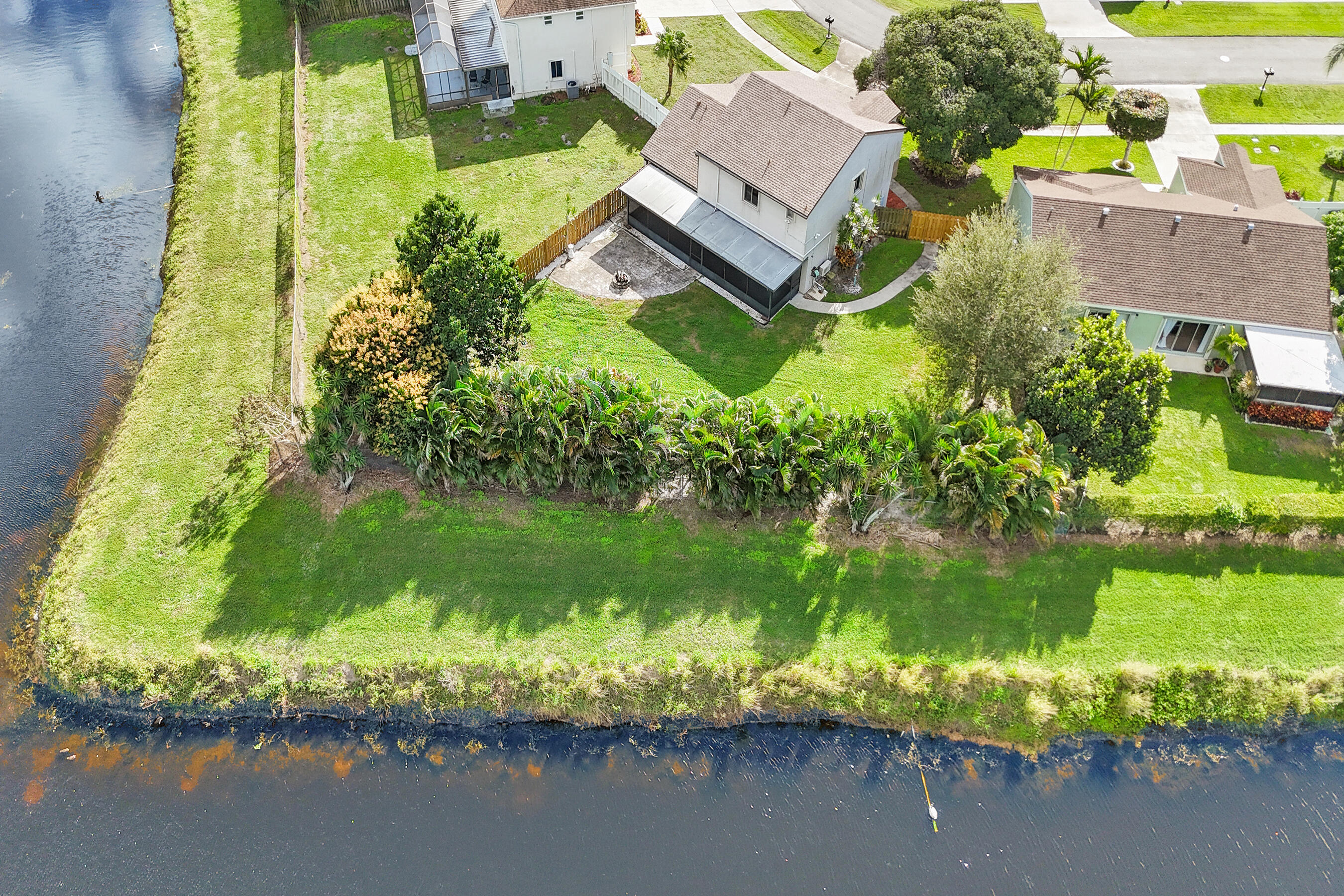 an aerial view of a house with a yard lake swimming pool and outdoor seating