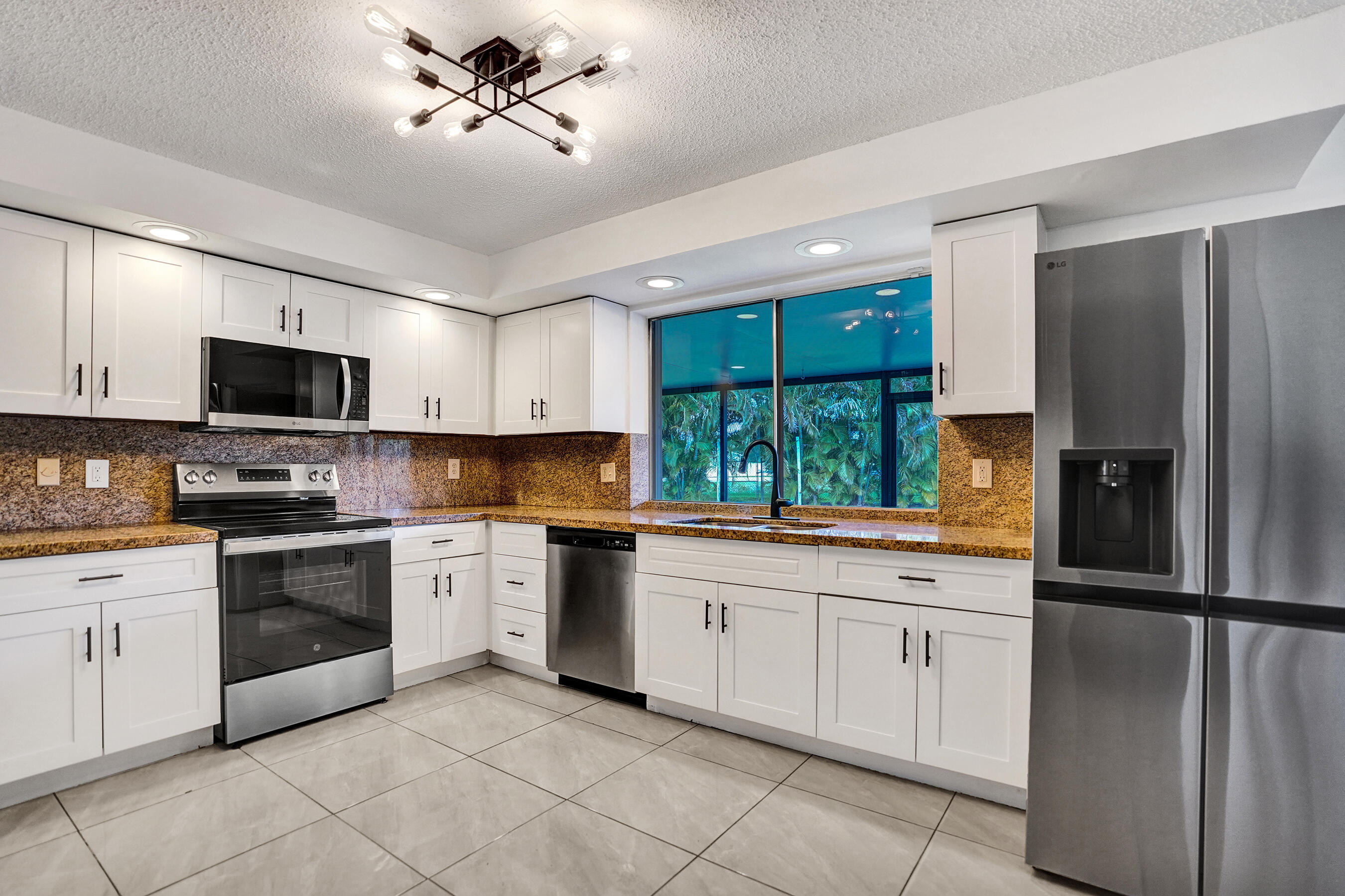 9855 Robins Nest Road Boca Raton, FL 33496 - Photo 11 of 84 a kitchen with a sink stainless steel appliances and white cabinets