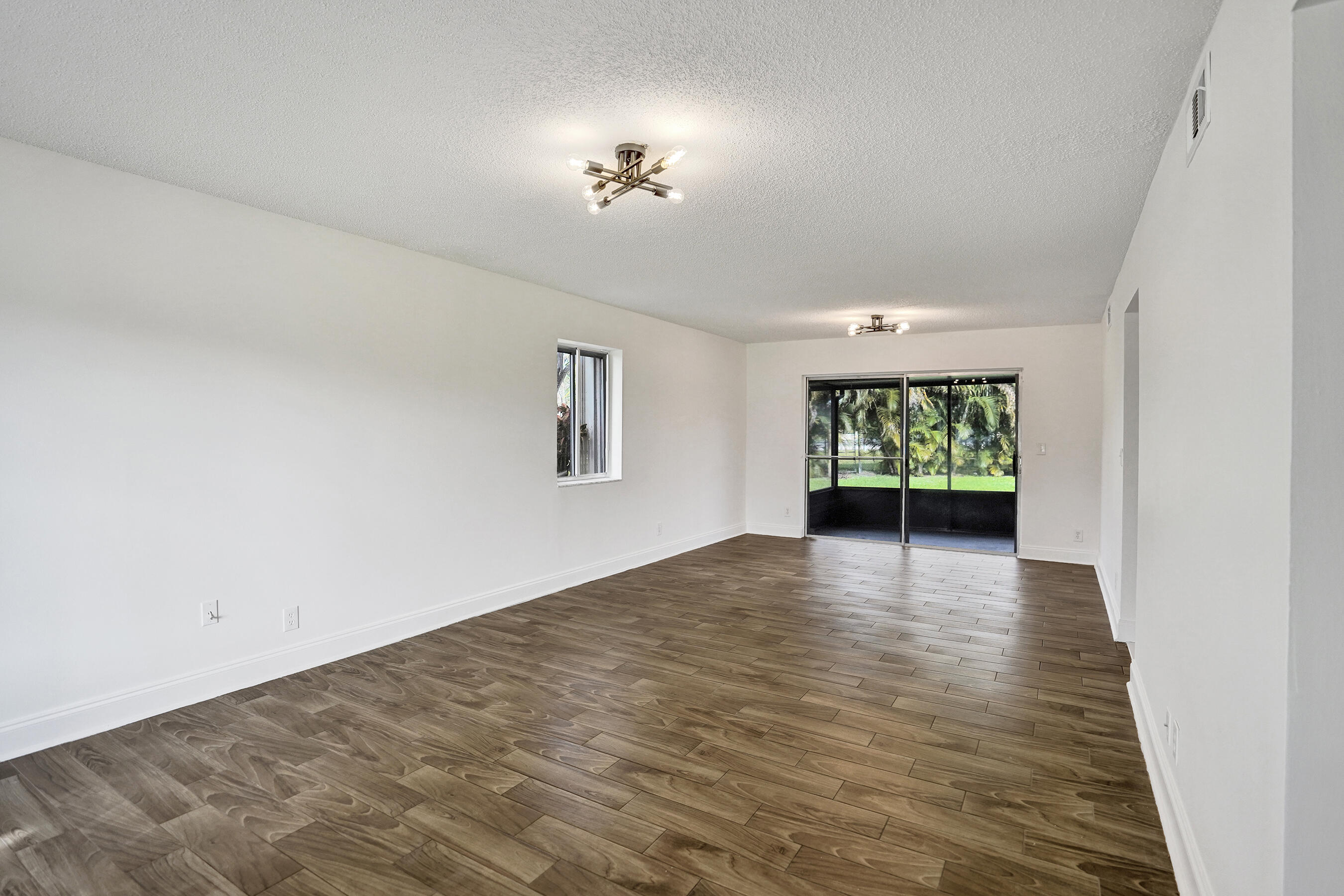 9855 Robins Nest Road Boca Raton, FL 33496 - Photo 15 of 84 a view of an empty room with a window and wooden floor