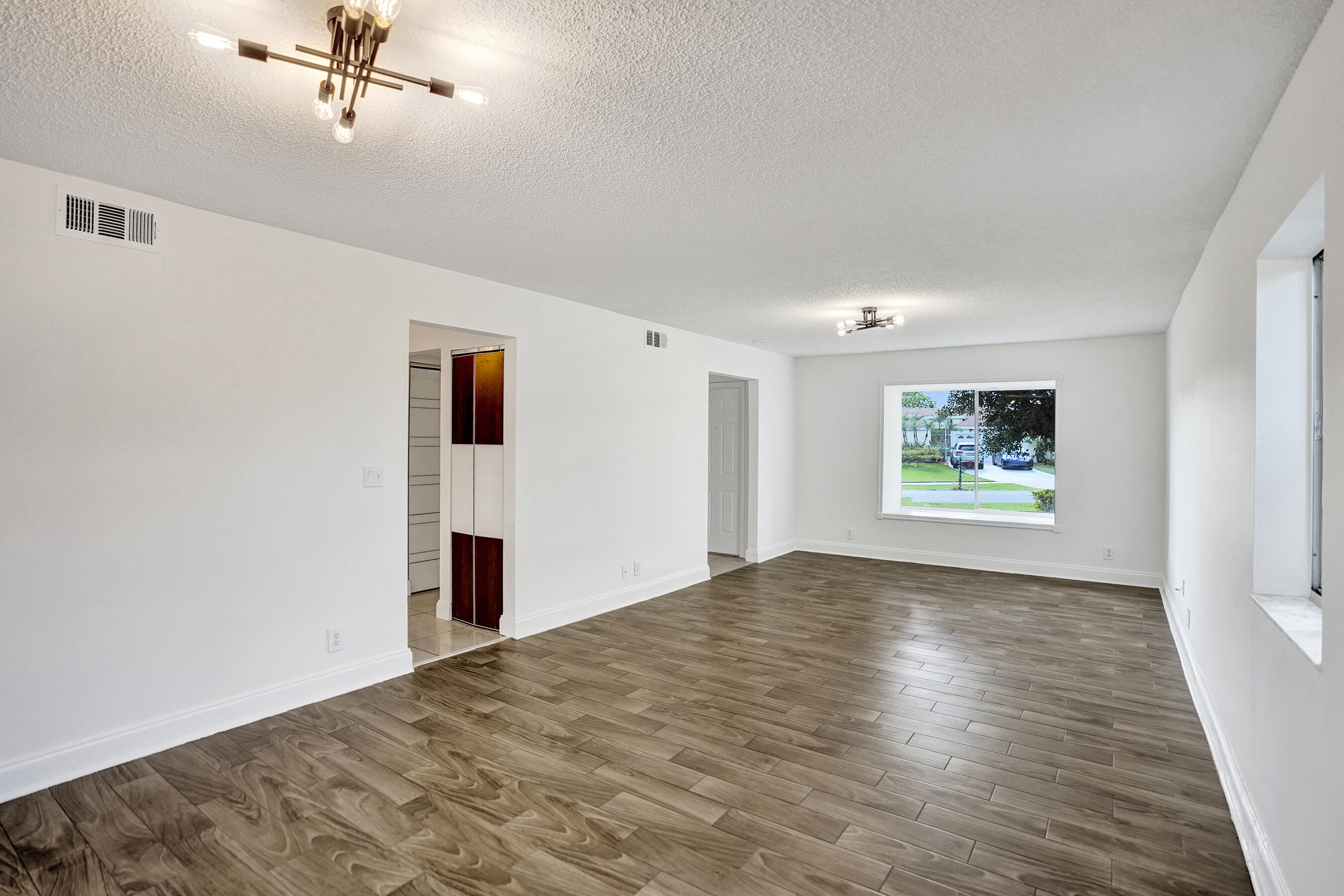 9855 Robins Nest Road Boca Raton, FL 33496 - Photo 19 of 84 a view of a big room with wooden floor and windows