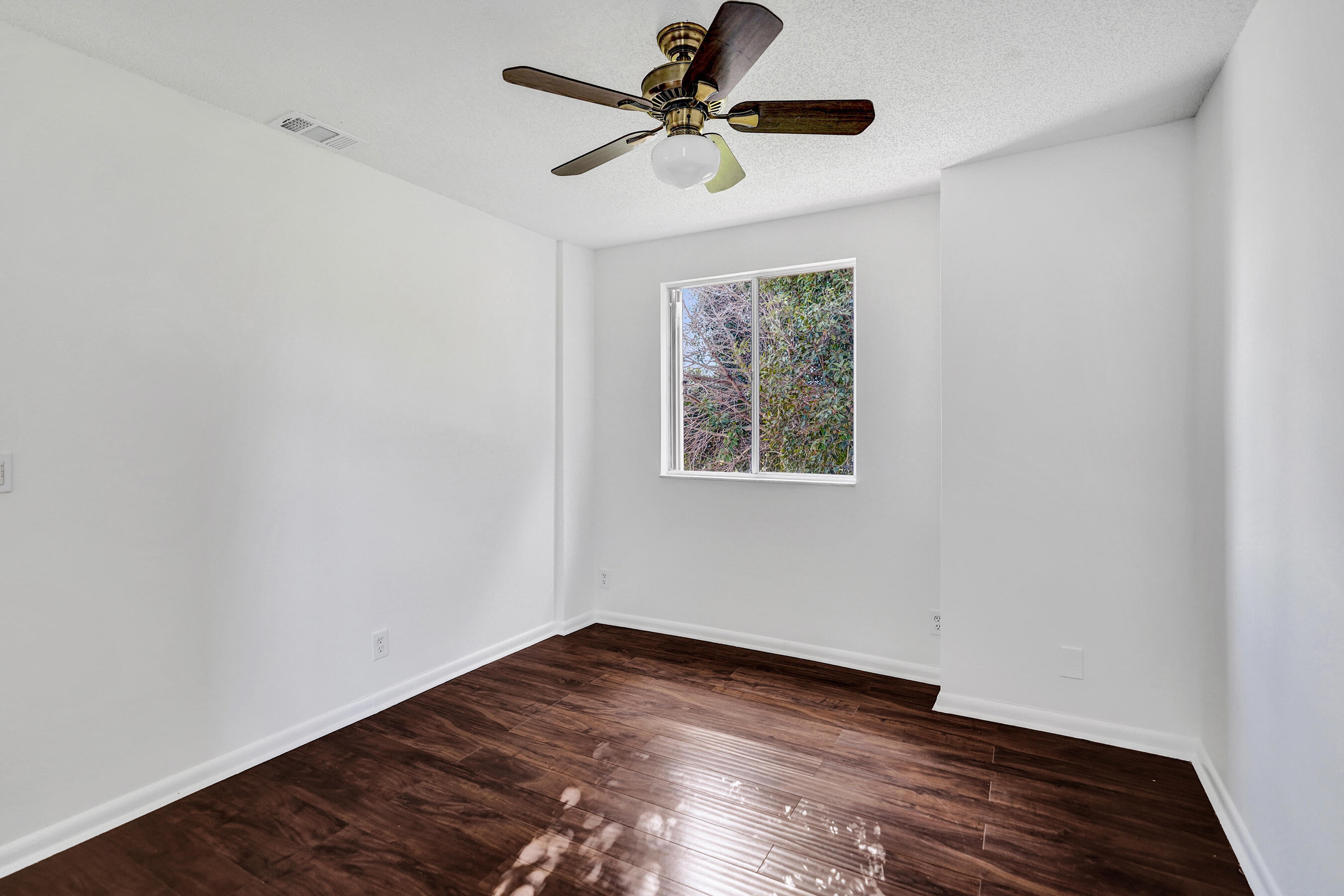 9855 Robins Nest Road Boca Raton, FL 33496 - Photo 29 of 84 an empty room with wooden floor ceiling fan and windows