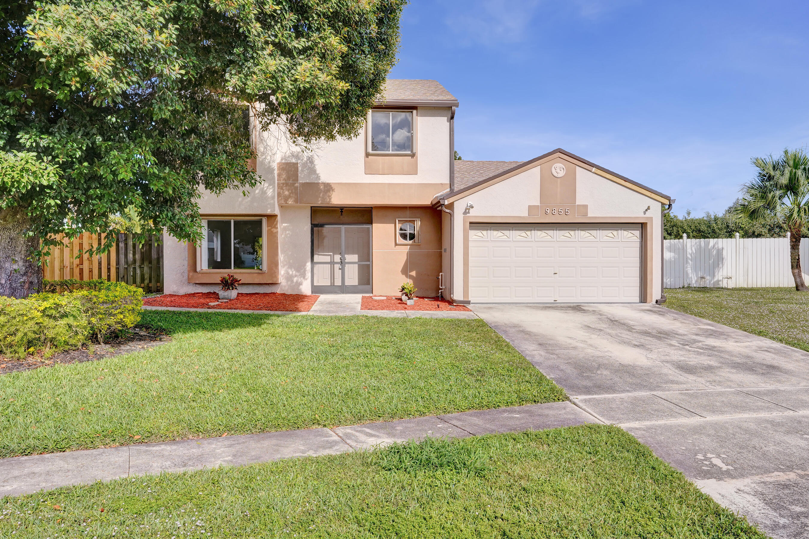 9855 Robins Nest Road Boca Raton, FL 33496 - Photo 3 of 84 a front view of a house with a yard