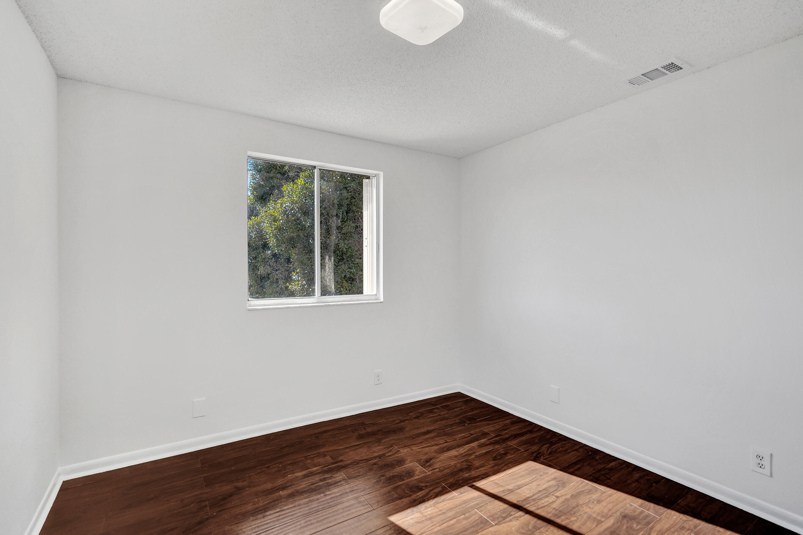 9855 Robins Nest Road Boca Raton, FL 33496 - Photo 37 of 84 a view of an empty room with wooden floor and a window