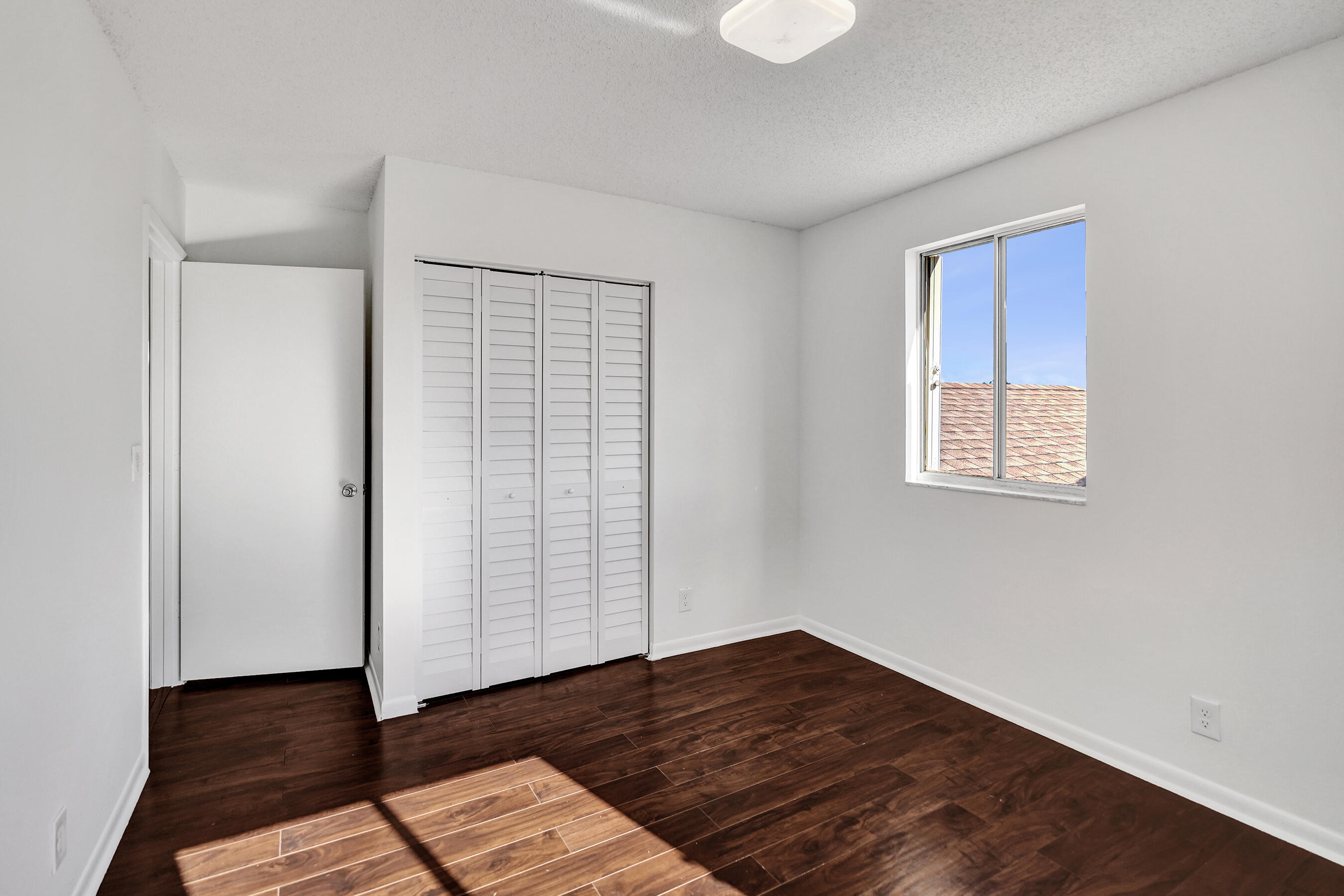 9855 Robins Nest Road Boca Raton, FL 33496 - Photo 39 of 84 a view of an empty room with wooden floor and a window