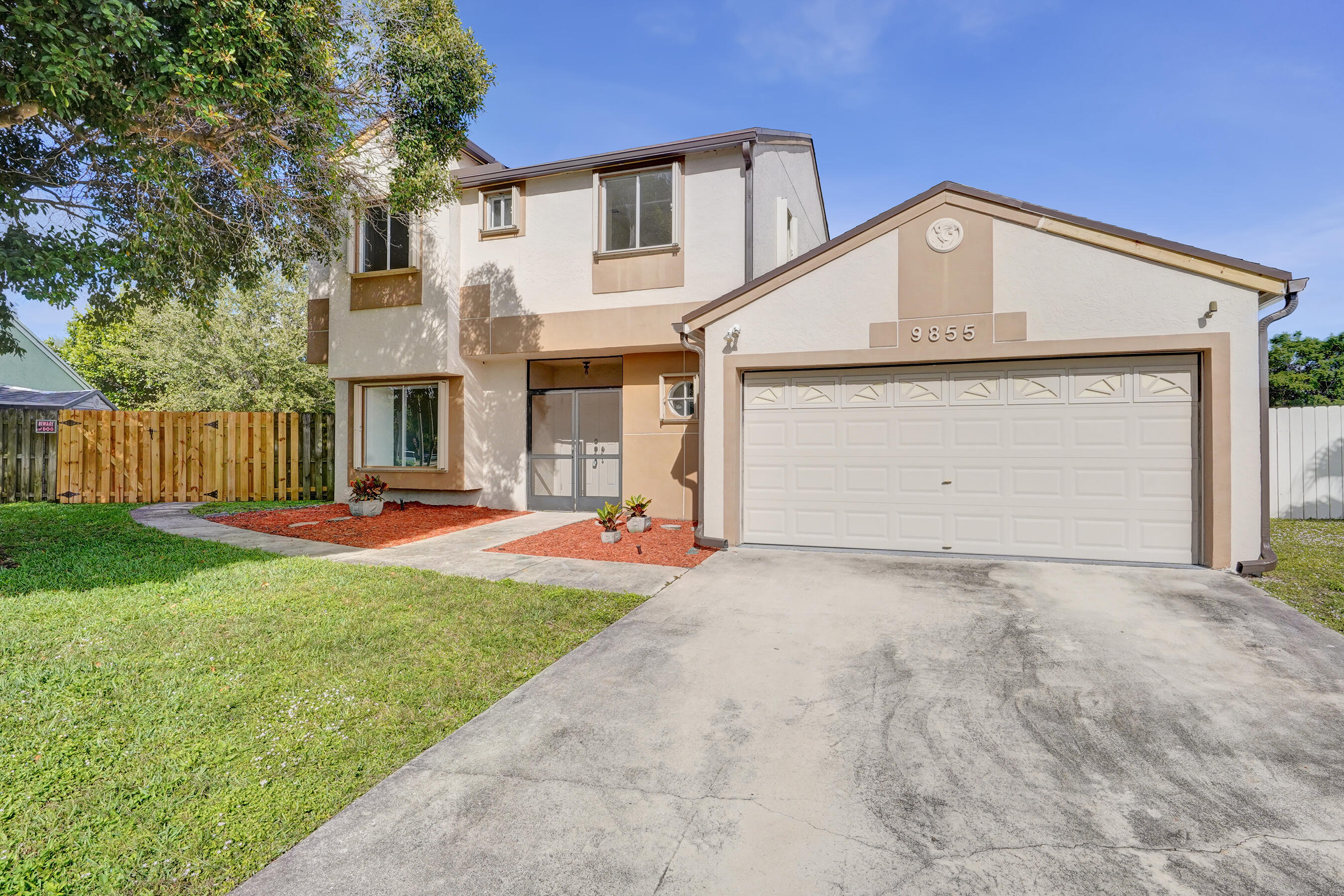 9855 Robins Nest Road Boca Raton, FL 33496 - Photo 4 of 84 a front view of a house with yard and garage