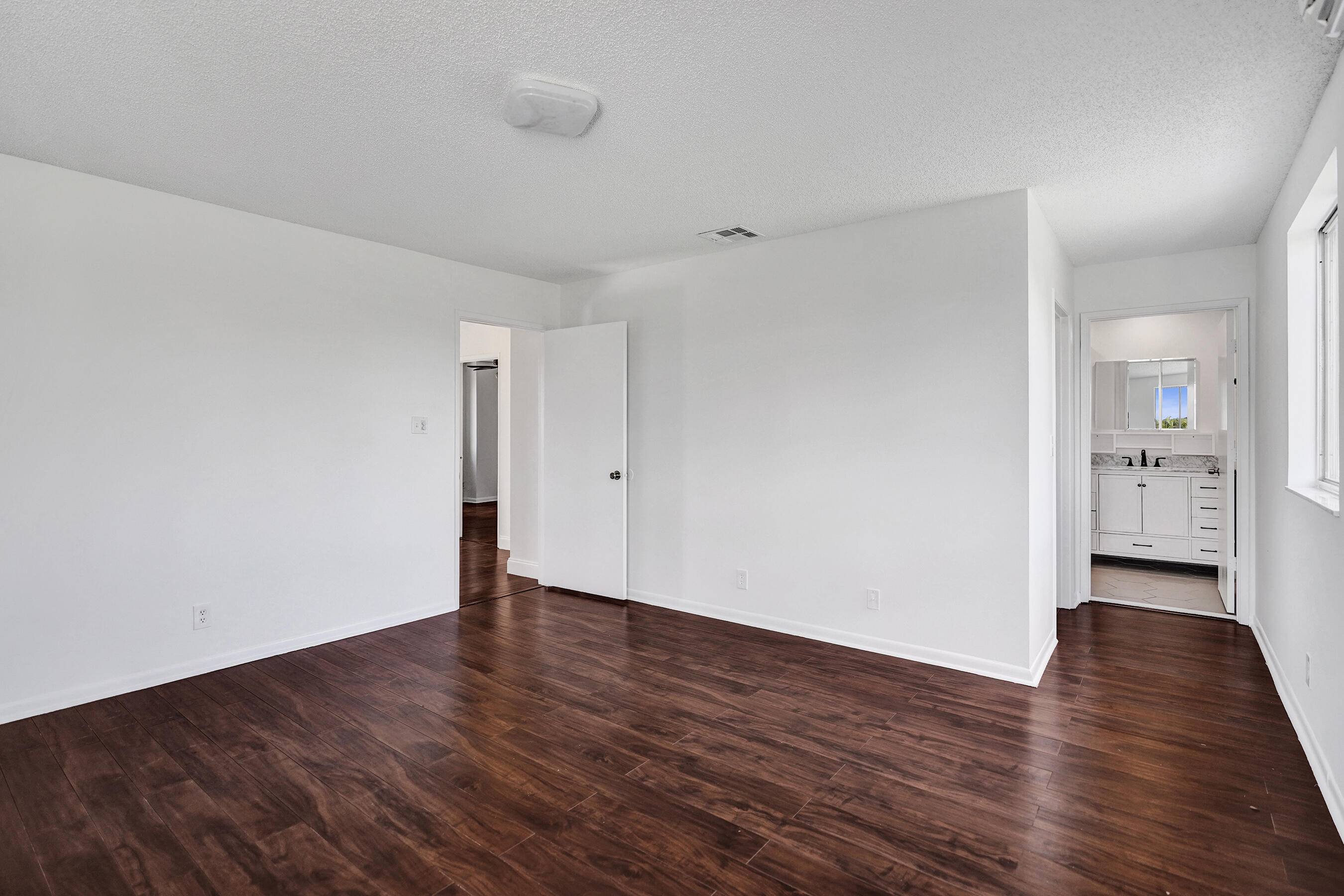 9855 Robins Nest Road Boca Raton, FL 33496 - Photo 42 of 84 a view of an empty room with wooden floor and a window