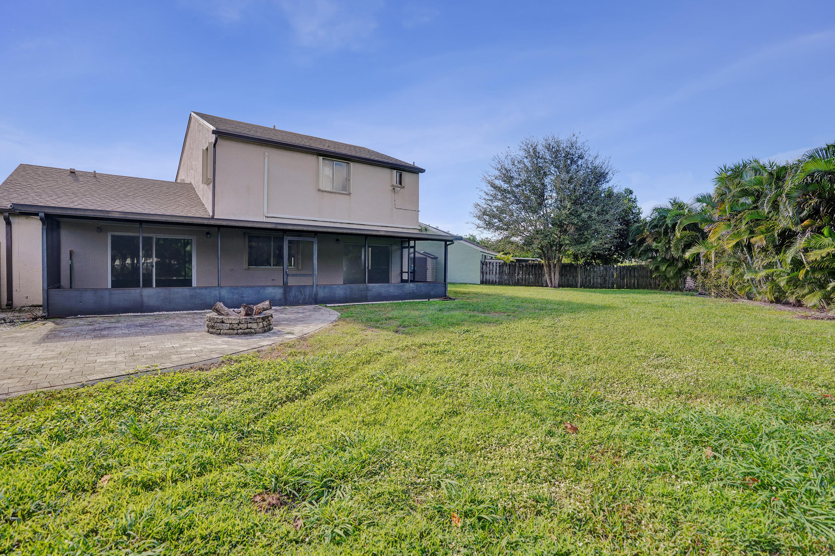 9855 Robins Nest Road Boca Raton, FL 33496 - Photo 61 of 84 a backyard of a house with table and chairs with plants and wooden fence