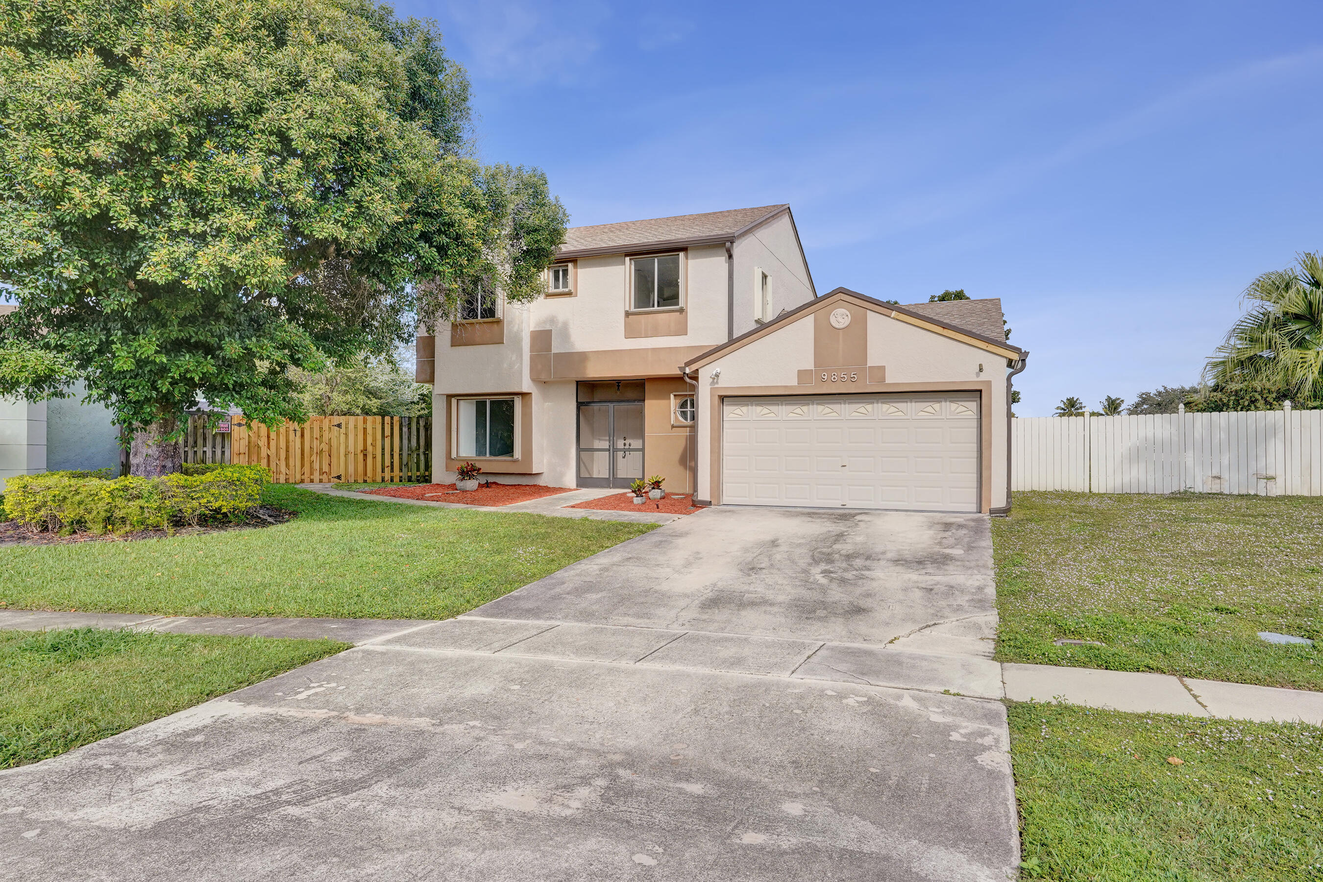 9855 Robins Nest Road Boca Raton, FL 33496 - Photo 66 of 84 a front view of a house with a yard and garage