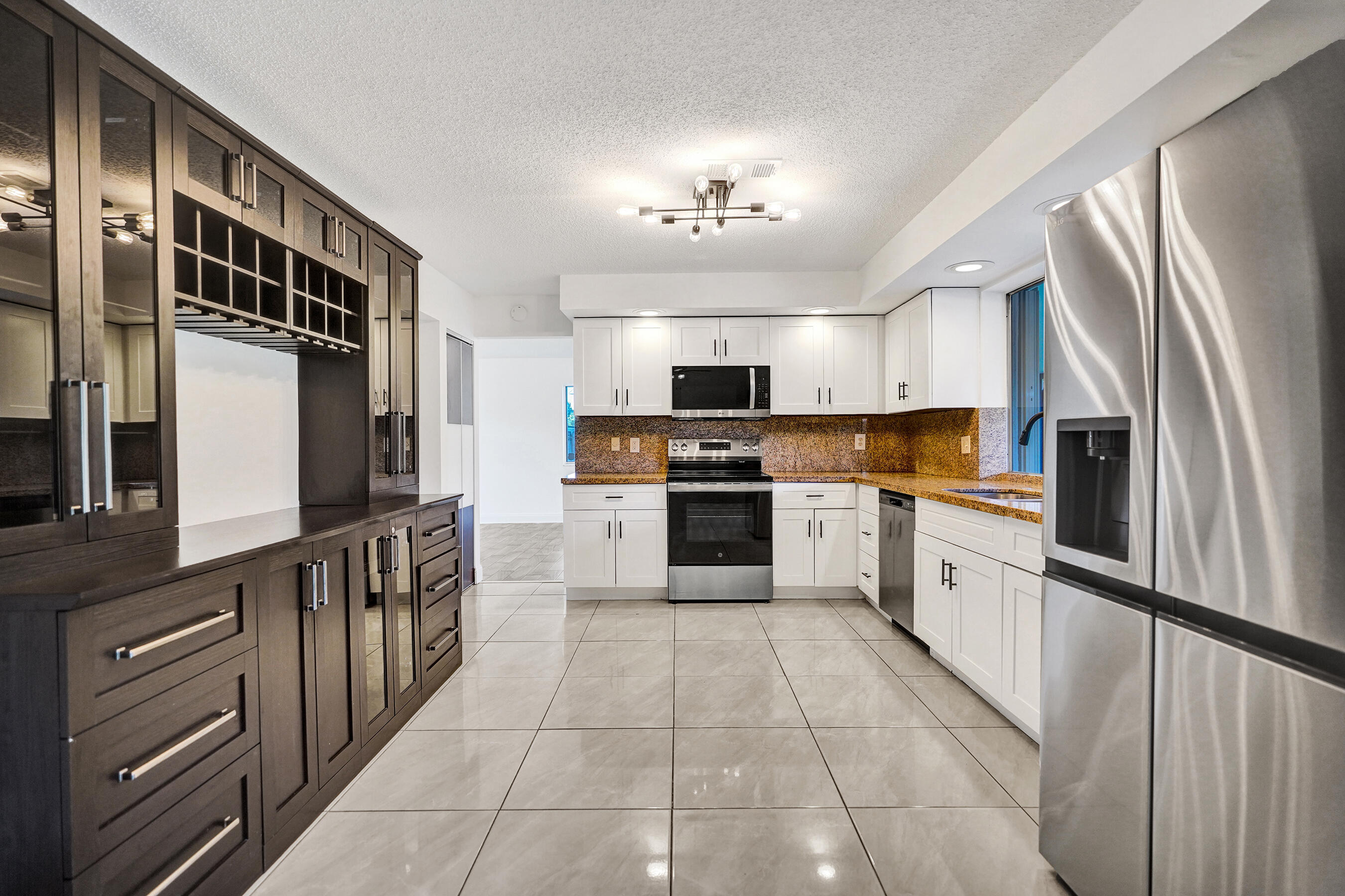 9855 Robins Nest Road Boca Raton, FL 33496 - Photo 7 of 84 a large kitchen with stainless steel appliances granite countertop a refrigerator and a stove top oven